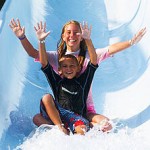 Mother and son slide down waterslide with hands up