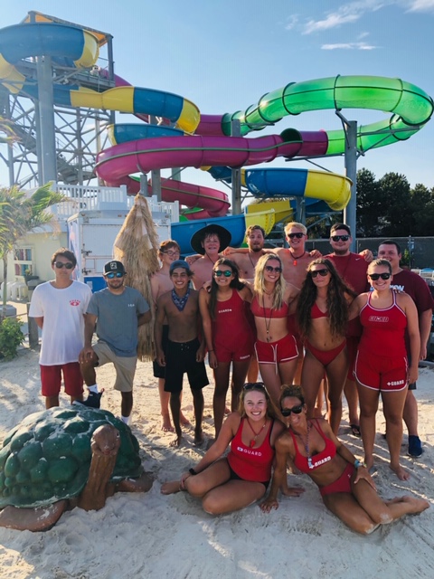 employees of waterpark standing in front of water slides posing for a picture